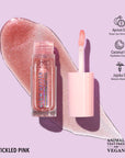 Lip gloss with applicator on a purple background, featuring ingredients.