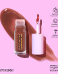 Lip gloss with applicator on a pink background, featuring ingredients and vegan