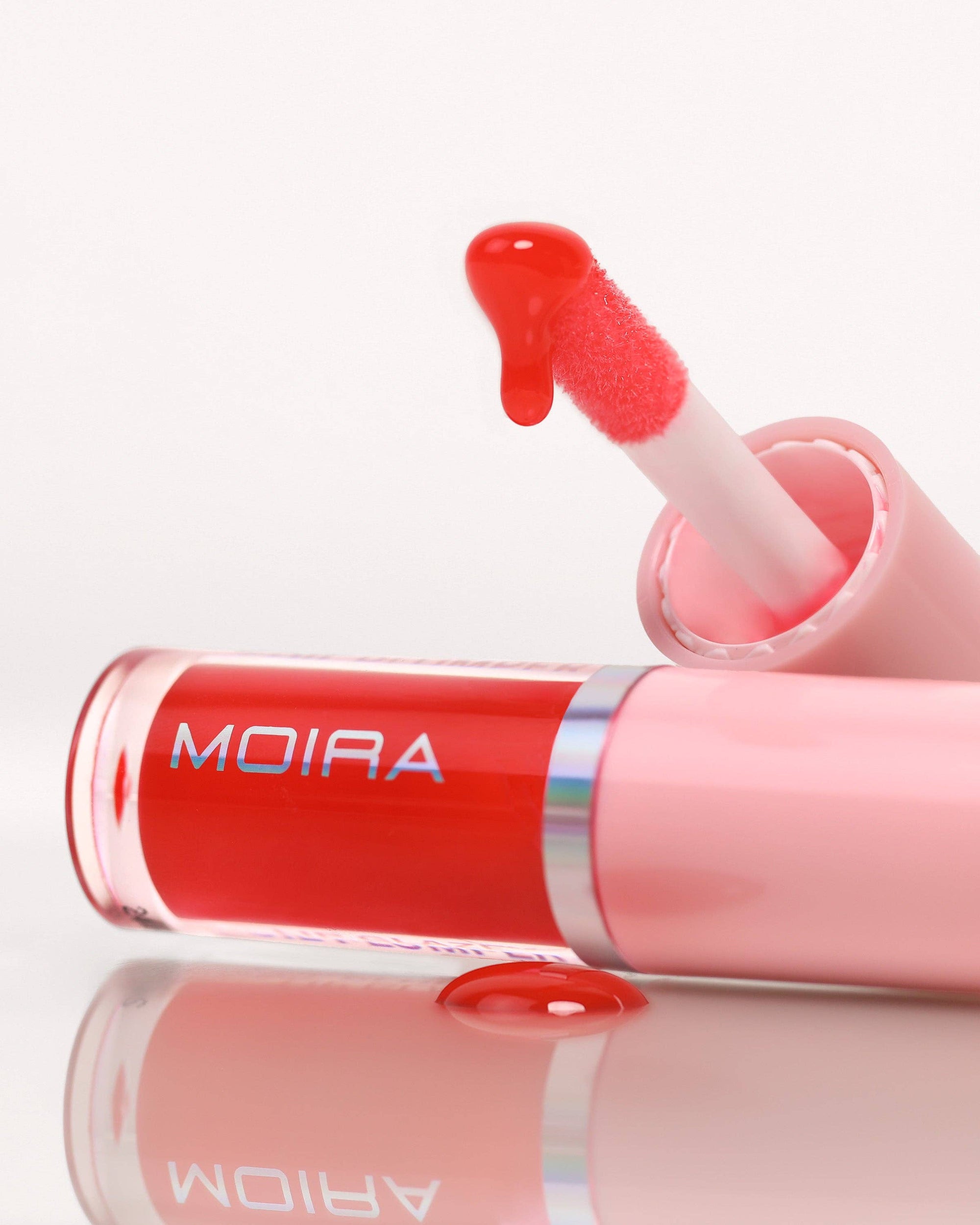 Red lip gloss with a pink applicator , featuring the brand 'MOIRA'.