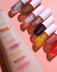 Set of lip glosses with swatches on a pink background