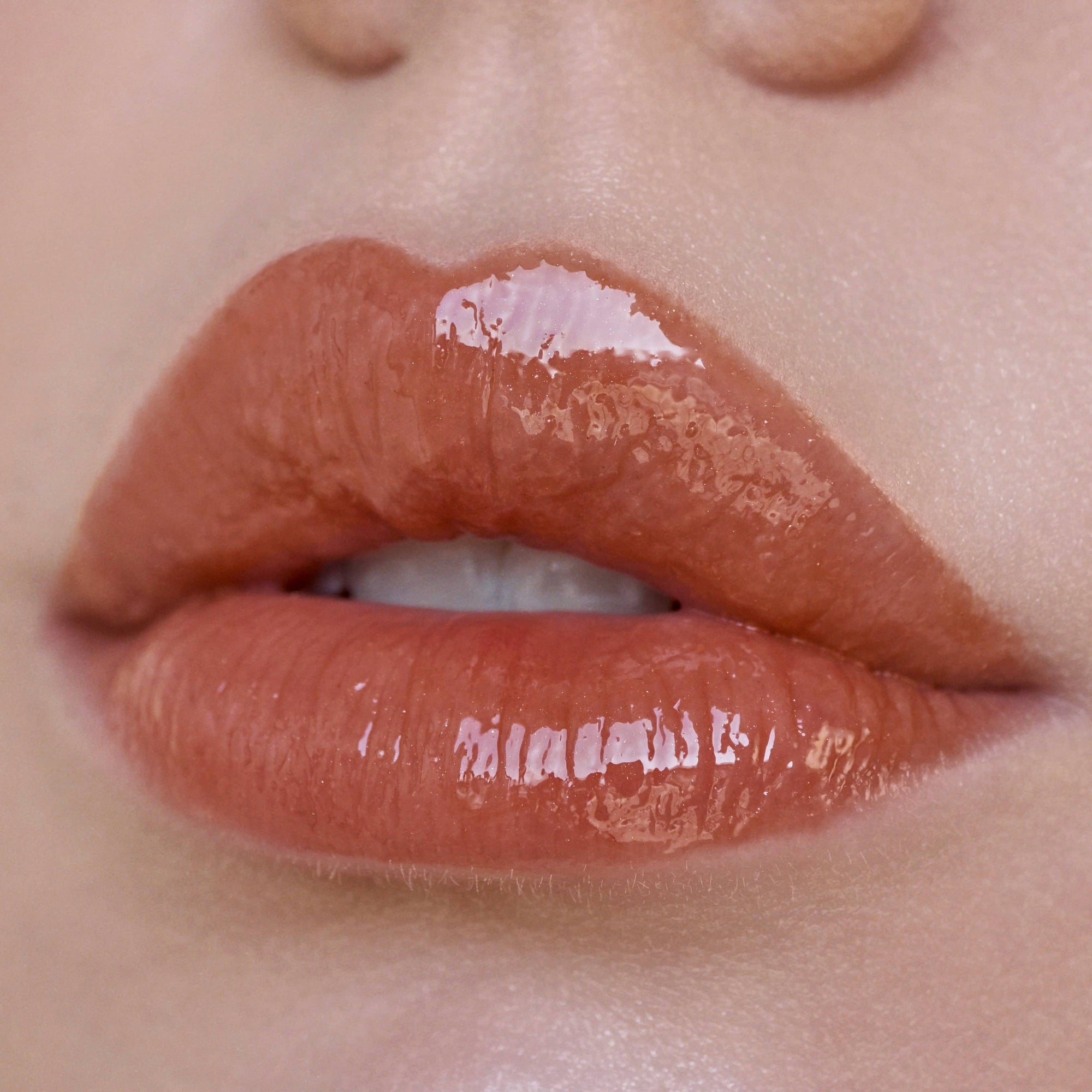 Close-up of glossy lips with a focus on texture and color.